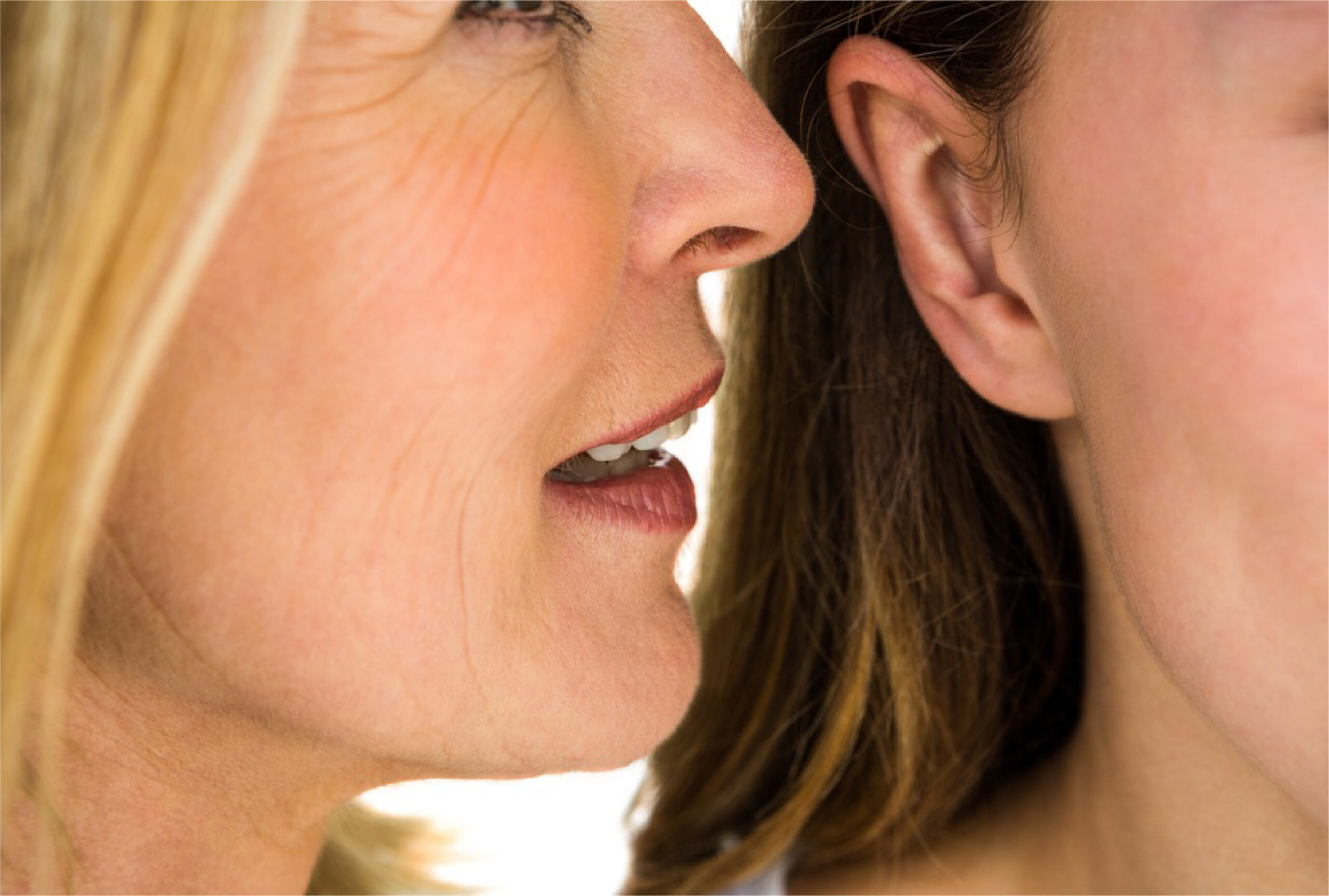 Femme chuchotant à l'oreille d'une autre femme