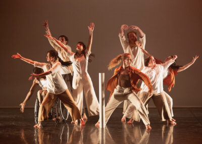 Groupe de danseurs contemporains sur scène éclairée