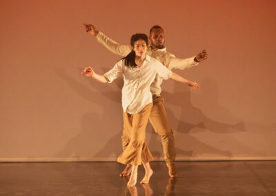 Deux danseurs contemporains sur scène bras étendus