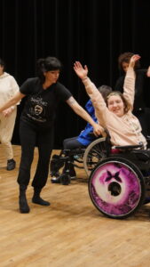 Danse inclusive en fauteuil roulant sur scène.