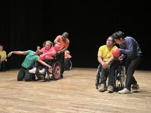 Personnes en fauteuil roulant avec des ballons rouges.